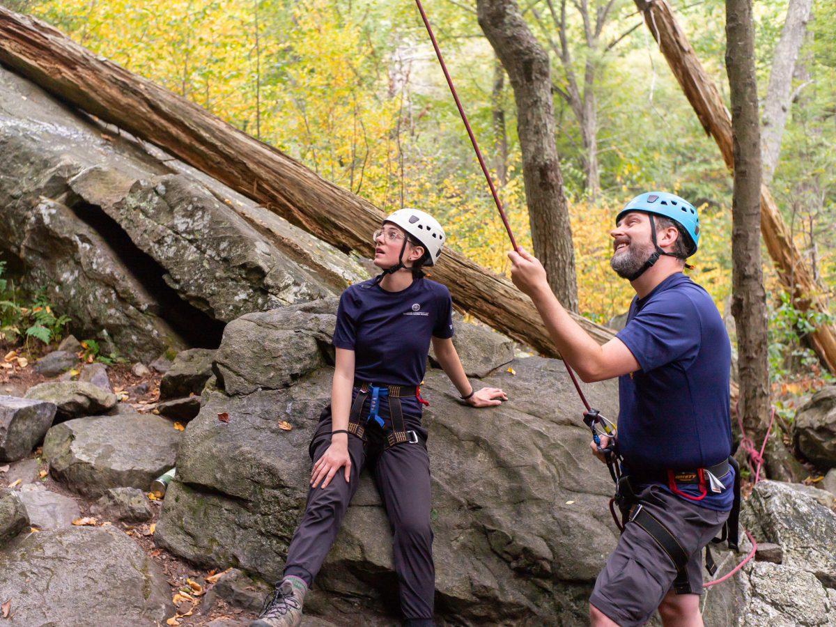 Board Chair Rogers belaying someone rock climbing while on an Outward Bound expedition.