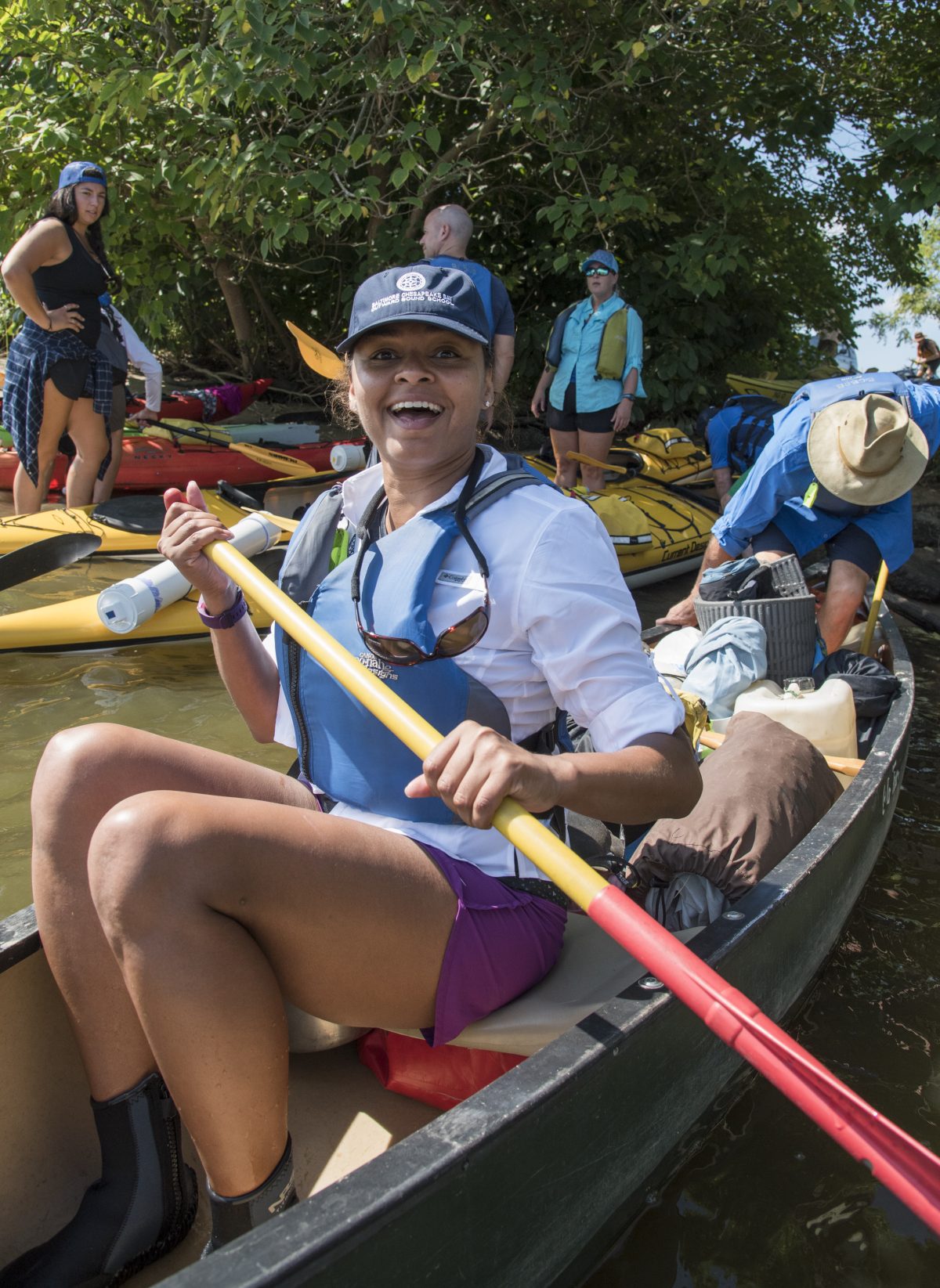 Vice-Chair Martin smiles while sitting in a canoe on an Outward Bound expedition.