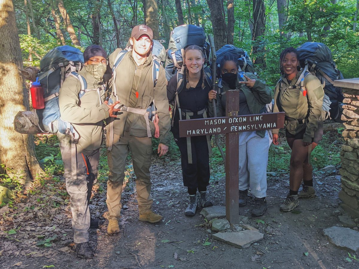 A crew of ROTC cadets in backpacks on the Appalachian Trail posing for a photo together.