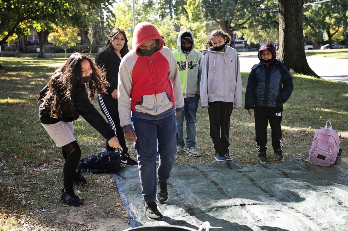 School students doing a team initiative together outside