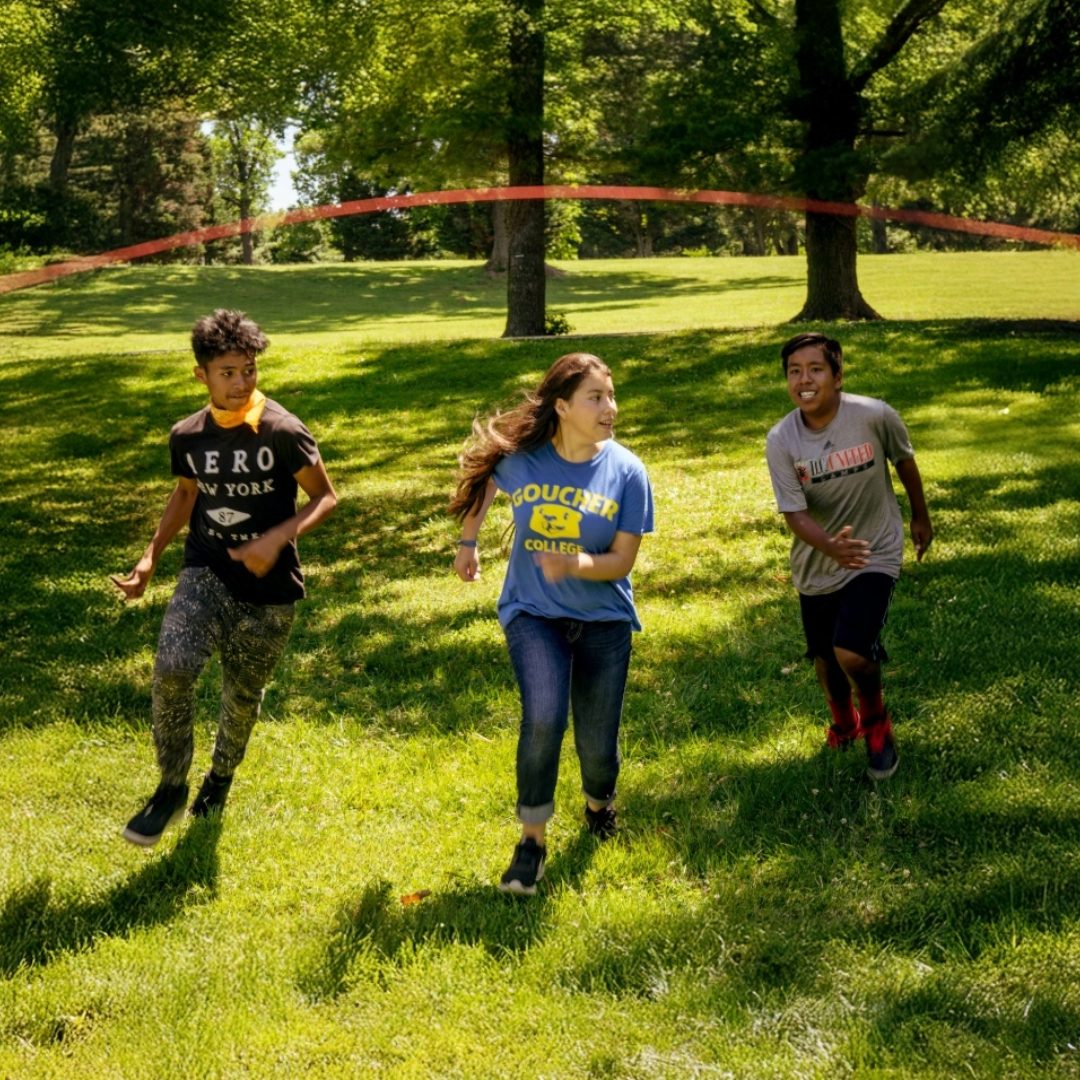 Youth running through a jump rope for a team building challenge