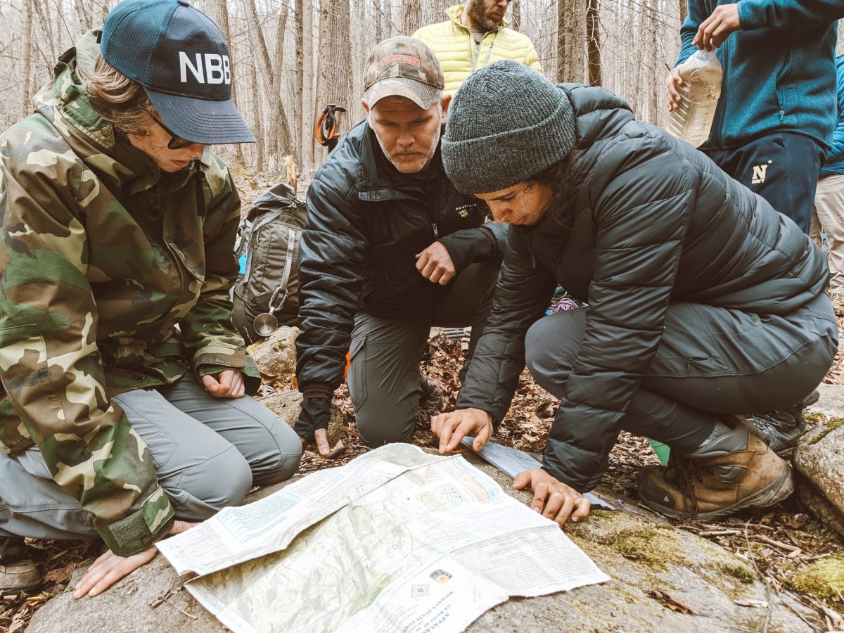 Maria looking at a map with two students