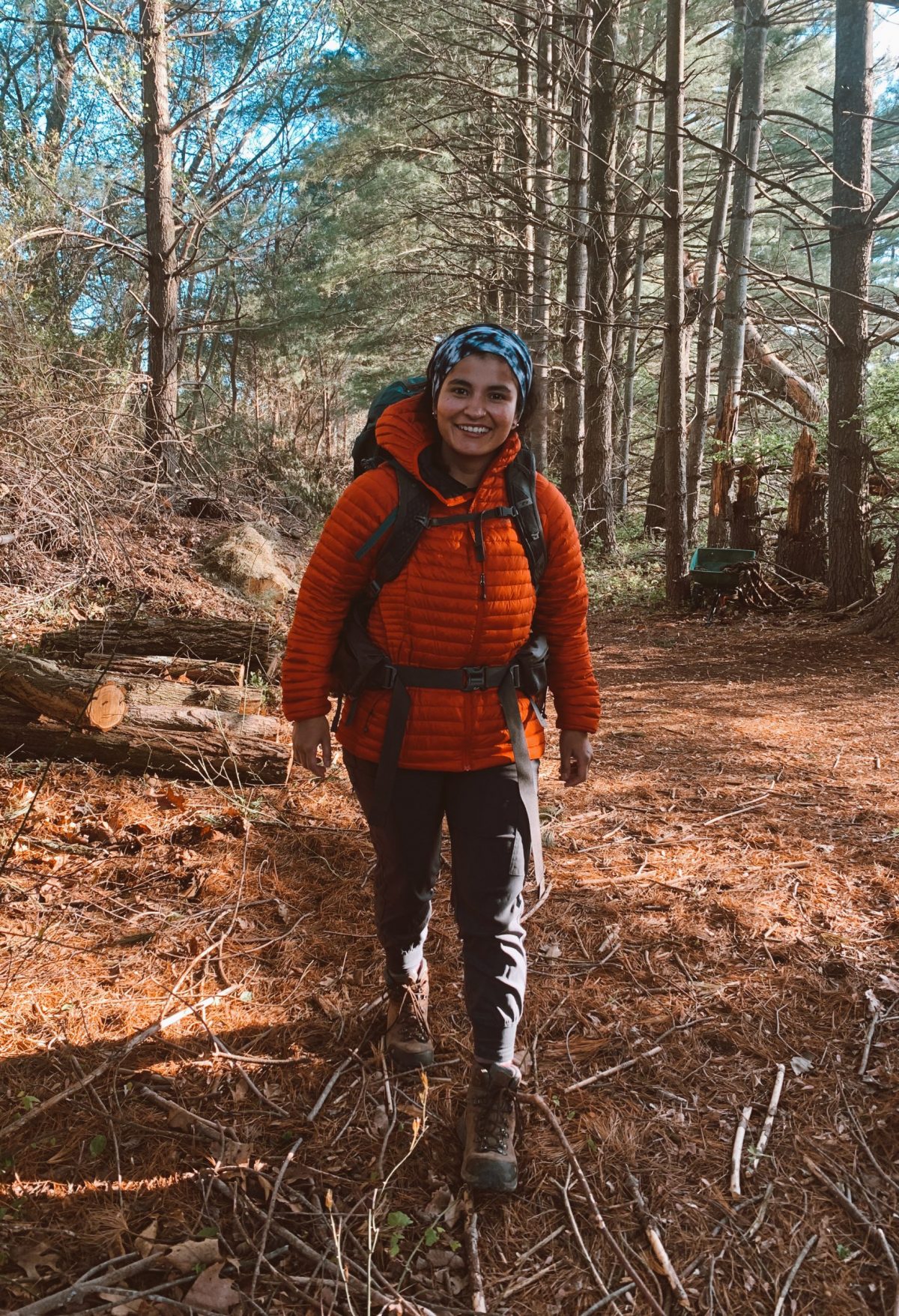 Maria with a backpack on in the woods
