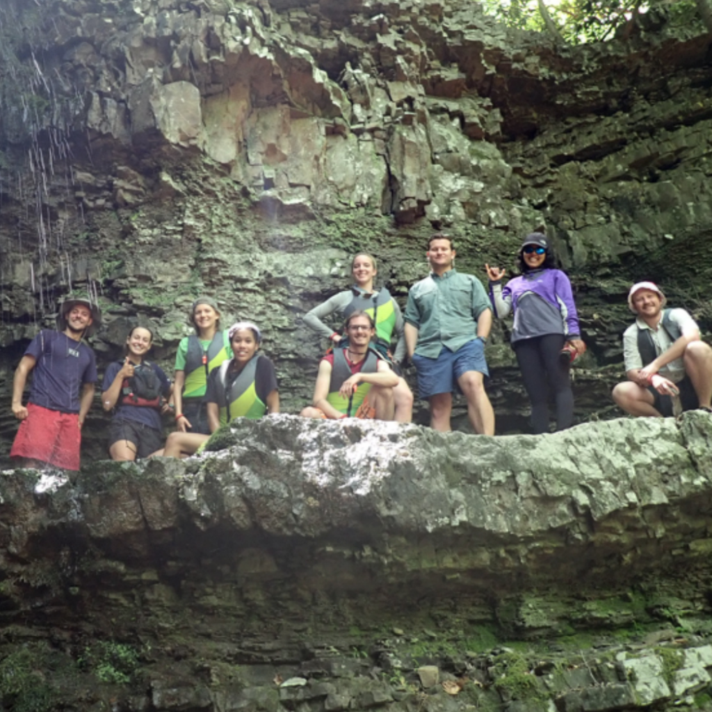 Crew of apprentices stand together in a small cave.